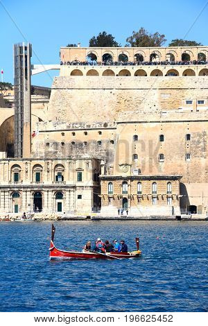 VALLETTA, MALTA - MARCH 31, 2017 - Passengers on board a traditional Maltese Dghajsa water taxi in the grand harbour with views towards Upper Barrakka Gardens Valletta Malta Europe, March 31, 2017.