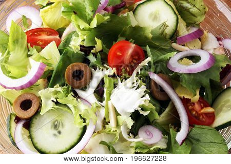 Bowl Of Salad With Vegetables And Greens On Wooden Table
