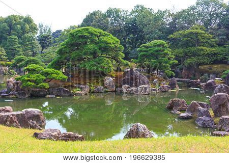 Ninomaru garden a traditional Japanese Zen garden in summer season with Bonsai trees stones pond and rock bridge. at Nijo Castle (Nijojo) famous historic site and tourist destination in Kyoto Japan.