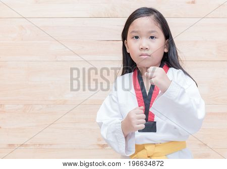 Asian taekwondo girl on acton on wood background sport and healthy concept