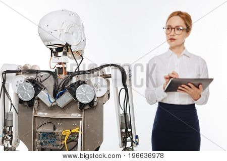Running tests. Diligent observant scrupulous woman trying out different algorithms while experimenting in a lab and developing artificial intelligence