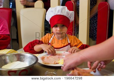 Alchevsk, Ukraine - July 23, 2017: School Cook For Children. Meat Rolls With Cheese Are Prepared.