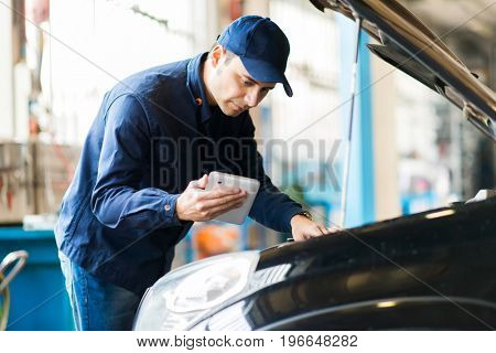 Mechanic using a tablet in his garage