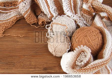 Balls of wool and knitting on the wooden background
