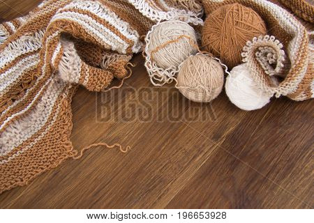Balls of wool and knitting on the wooden background