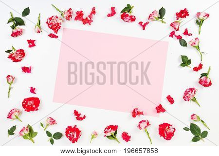 Flowers composition. Frame made of rose flowers. Empty blank sheet of paper in the middle. Flat lay, top view.