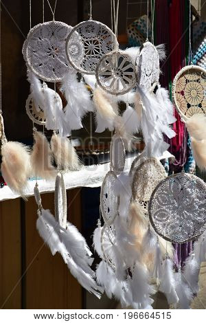 Dream Catchers, made of white lace and feathers, swing in the wind