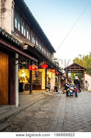 Suzhou, China - Nov 5, 2016: Shopping street at the historic Zhouzhuang Water Town. Numerous visitors can be seen walking along this path.