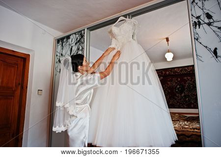 Fabulous Bride Holding Her Sophisticated White Wedding Dress.