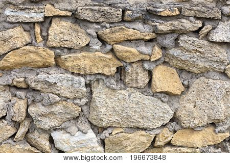 Stone wall of old limestone stones. Abstract texture
