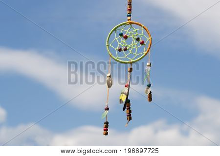 Dream catcher in the wind against the sky