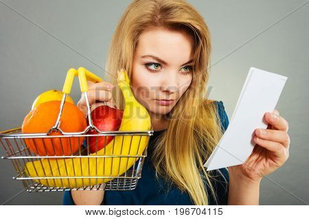 Worried Woman Holding Shopping Basket With Fruits