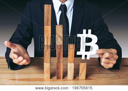 Business Economic crisis concept Businessman holding showing bitcoin symbol concede decrease of price and Depression of the economy. wooden block of the financial crisis of income in bitcoins.
