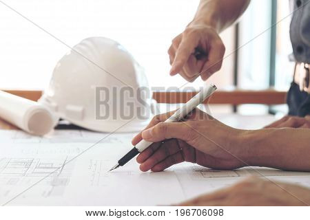 Image of engineer or architectural project Close up of hands architects engineering working on blueprint with engineering equipment tool Construction concept.