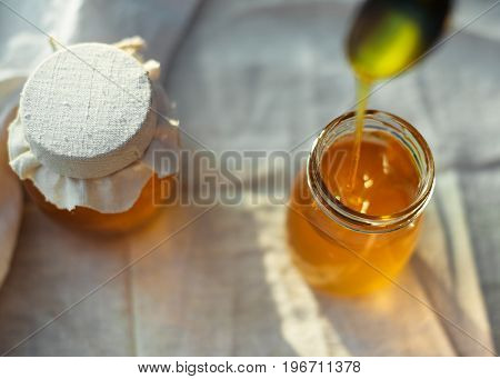 Two cans of natural honey. Honey on the fabric.