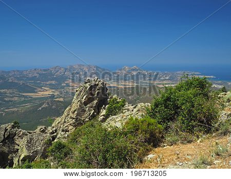 Sharp Stones Mountain Sea View With A Blue Sky And Green Bushes