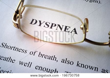 Paper with word dyspnea (shortness of breath) and glasses.