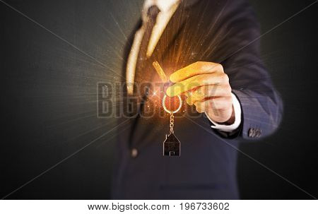 Formal man hand over shiny keys with dark background