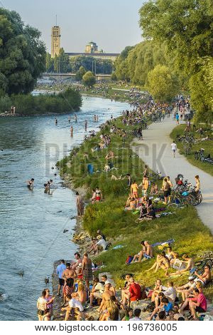 Unidentified people enjoy the sunset on Isar river on July 07 2015 in Munich Bavaria Germany.