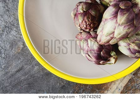 Baby Ripping Organic Artichokes With Lemon. Food For A Vegan And