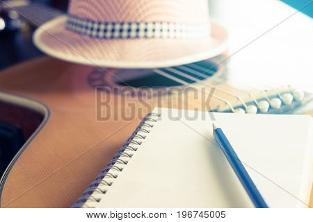 Blank notebook on acoustic guitar for songwriter