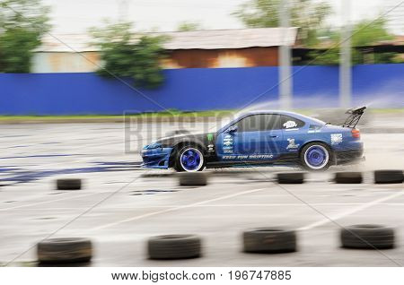 Orel Russia July 22 2017: Dynamica car festival. Tuned car riding swiftly along tyre line with water splashes motion blur