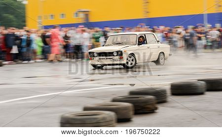 Orel Russia July 22 2017: Dynamica car festival. Tuned white vintage Russian VAZ Lada car drifting in water puddles at rainy day