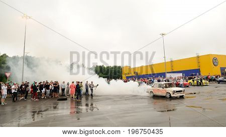 Orel Russia July 22 2017: Dynamica car festival. Tuned vintage Russian VAZ Lada car drifting in burning wheel smoke clouds panoramic view