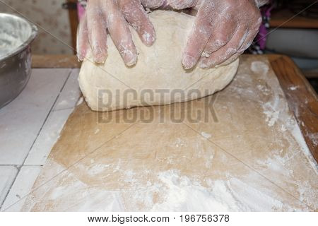 Top view shot of female hands mixing dough. Female hands knead dough on wooden board. 4k prores footage