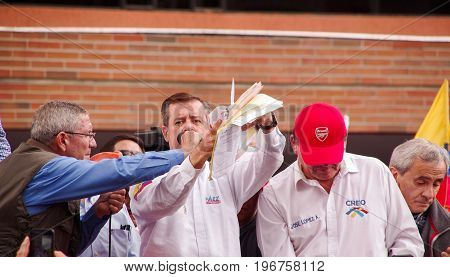 Quito, Ecuador - April 7, 2016: Closeup opposition leader Andres Paez surrounded by people and holding in his hands proofs of election fraud, police and journalists during anti government protests in Shyris Avenue.