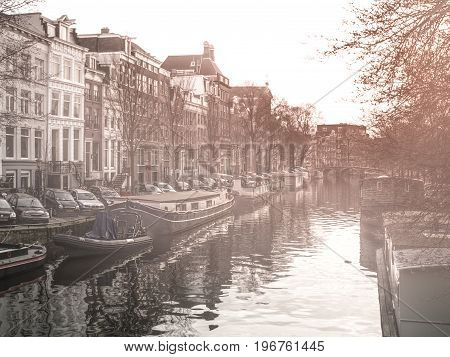 Morning haze at water canal, gracht, in Amsterdam, Netherlands