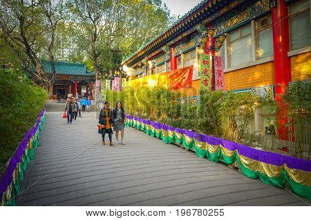 HONG KONG, CHINA - JANUARY 22, 2017: Unidentified people walking through the enter of Wong Tai Sin Buddhist Temple to pray, in Hong Kong, China.