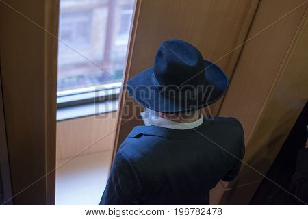 Jew Hasid Ethnic Headdress. The Jew Prays Before The Window. View From Above