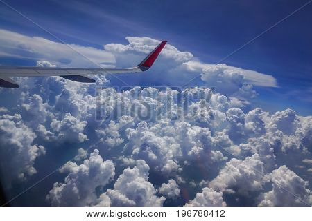 Wing of the plane flying in the sky and the sea of clouds.