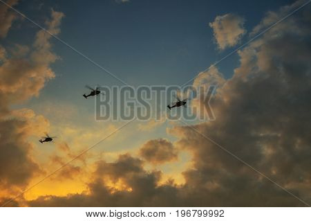 helicopters flying on a background of sunset sky. Three helicopters in the sky