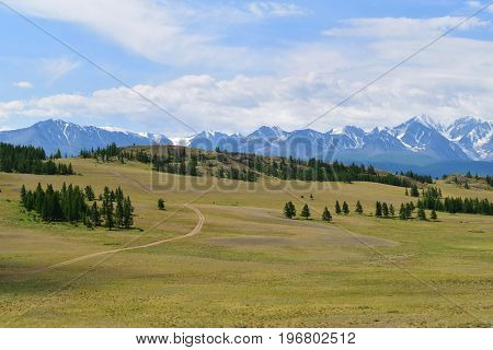 Kurai steppe andwhite peaks of North-Chiyski ridge in Altai mountains in cloudy weather. Altay Republic Siberia Russia.