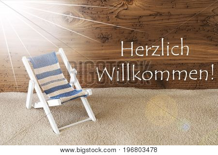 Sunny Summer Greeting Card With Sand And Aged Wooden Background. German Text Willkommen Means Welcome. Deck Chair For Holiday Or Vacation Feeling.