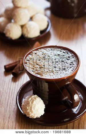 Kopp kaffe och vit choklad tryffel på bord