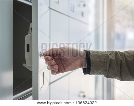 Hand with Key Open Locker in Locker room