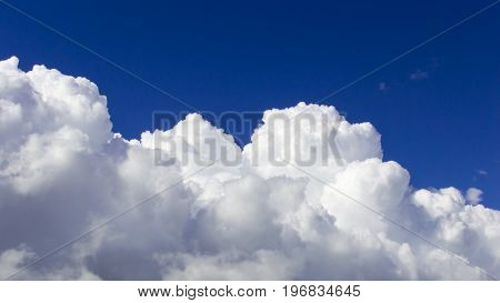 a big and fluffy cumulonimbus cloud in the blue sky.