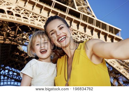 Happy Mother And Child Taking Selfie In Front Of Eiffel Tower