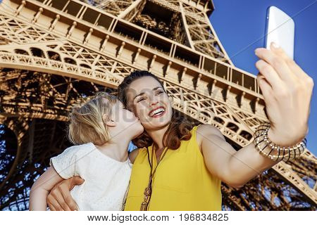 Mother And Daughter Tourists Taking Selfie Near Eiffel Tower