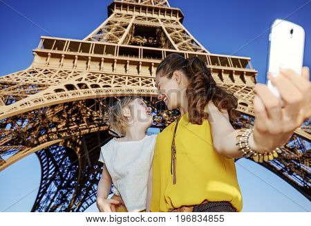 Mother And Daughter Tourists Taking Selfie Against Eiffel Tower