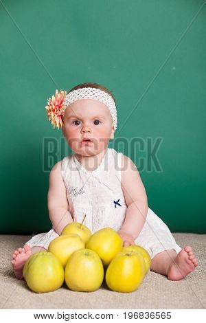 baby girl in a dress with Green apples 1