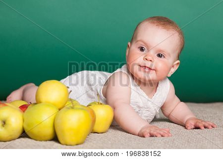 baby girl in a dress with Green apples 1