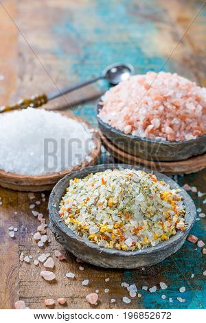 Three Different Types Of Natural Salt In Stone Bowls On Wooden Surface. White Sea Salt, Pink Himalay