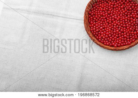 Juicy red current in a light brown basket on a gray background. Berries full of vitamins. Delicious organic red berries. Nutritious foods for diet.