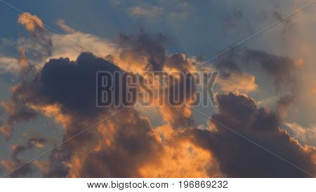 dramatic dark and orange clouds on the blue sky background