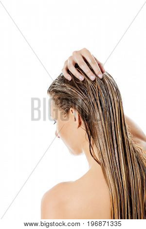 Photo of woman applying hair conditioner.
