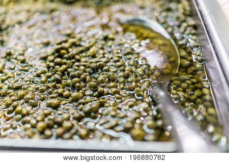 Macro Closeup Of Small Green Capers In Olive Bar